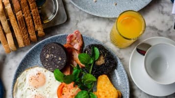 A breakfast plate with eggs, bacon, black pudding, and toast.
