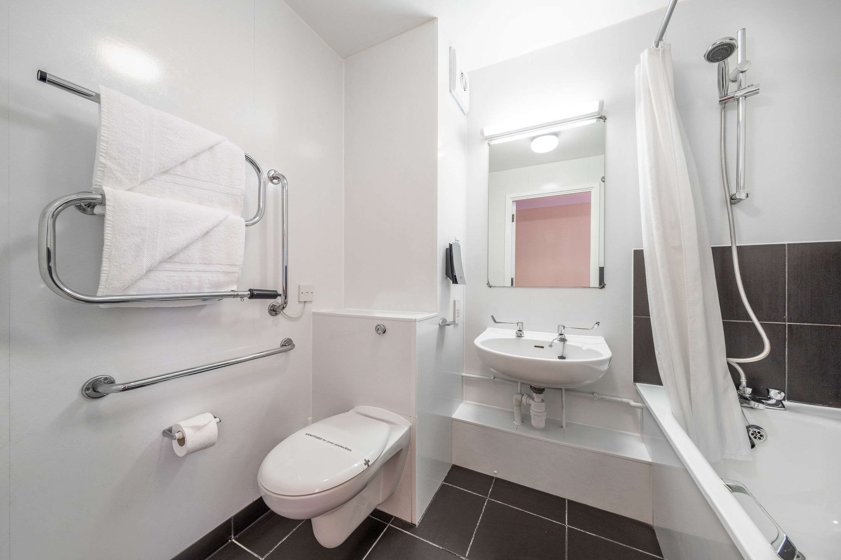 Un baño moderno con inodoro, lavamanos y ducha.
