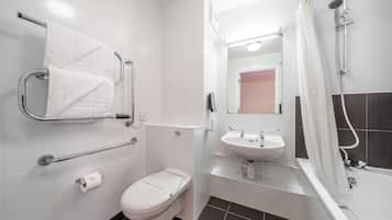 Un baño moderno con inodoro, lavamanos y ducha.