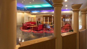 A hotel lobby with a central seating area, a patterned carpet, and a ceiling with recessed lighting. - Roundhouse Hotel Bournemouth (Bournemouth)