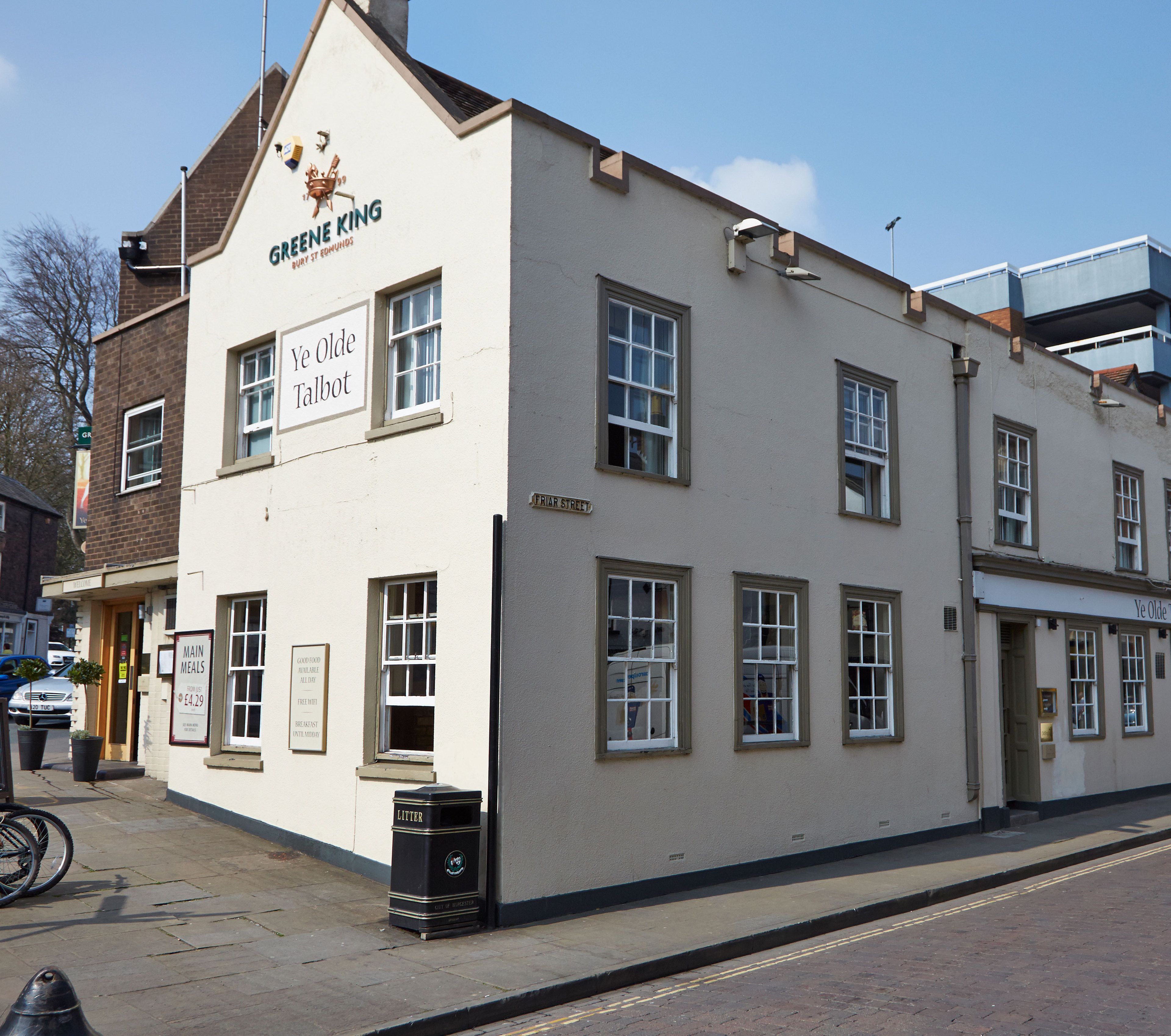 A building with a sign reading "Greene King Ye Olde Talbot" and a sign for "Main Meals" priced at £4.29.