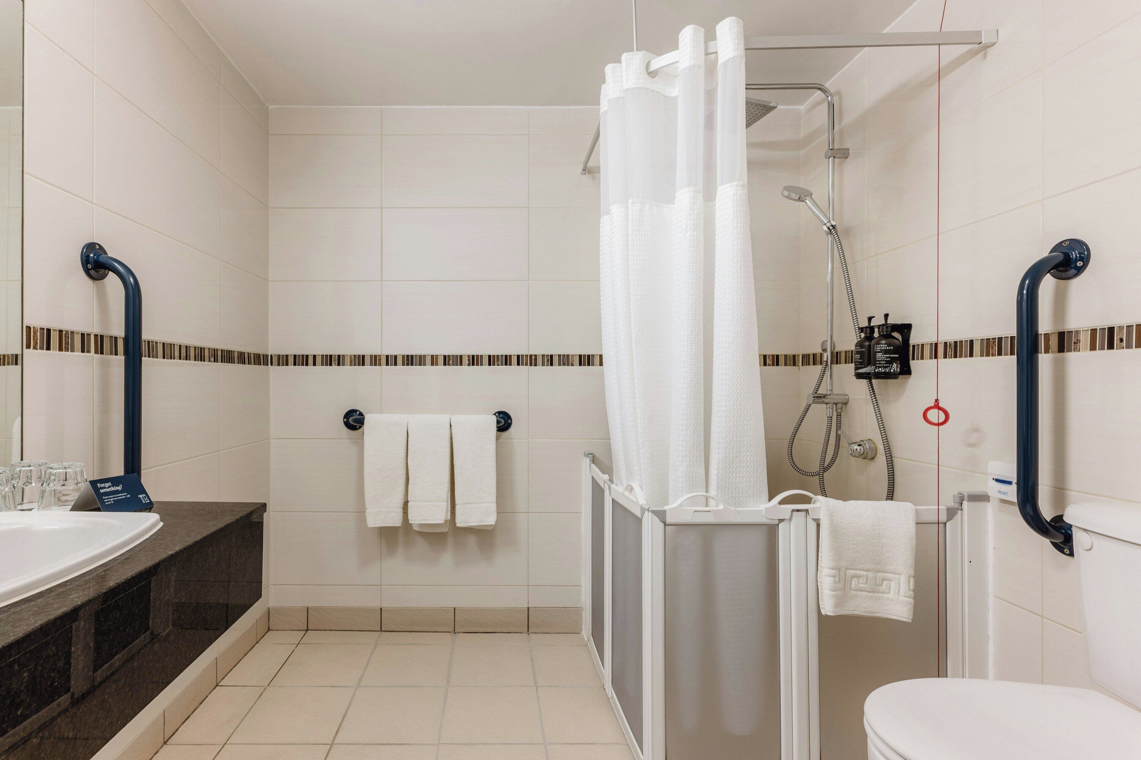 A bathroom with a shower, toilet, and sink.