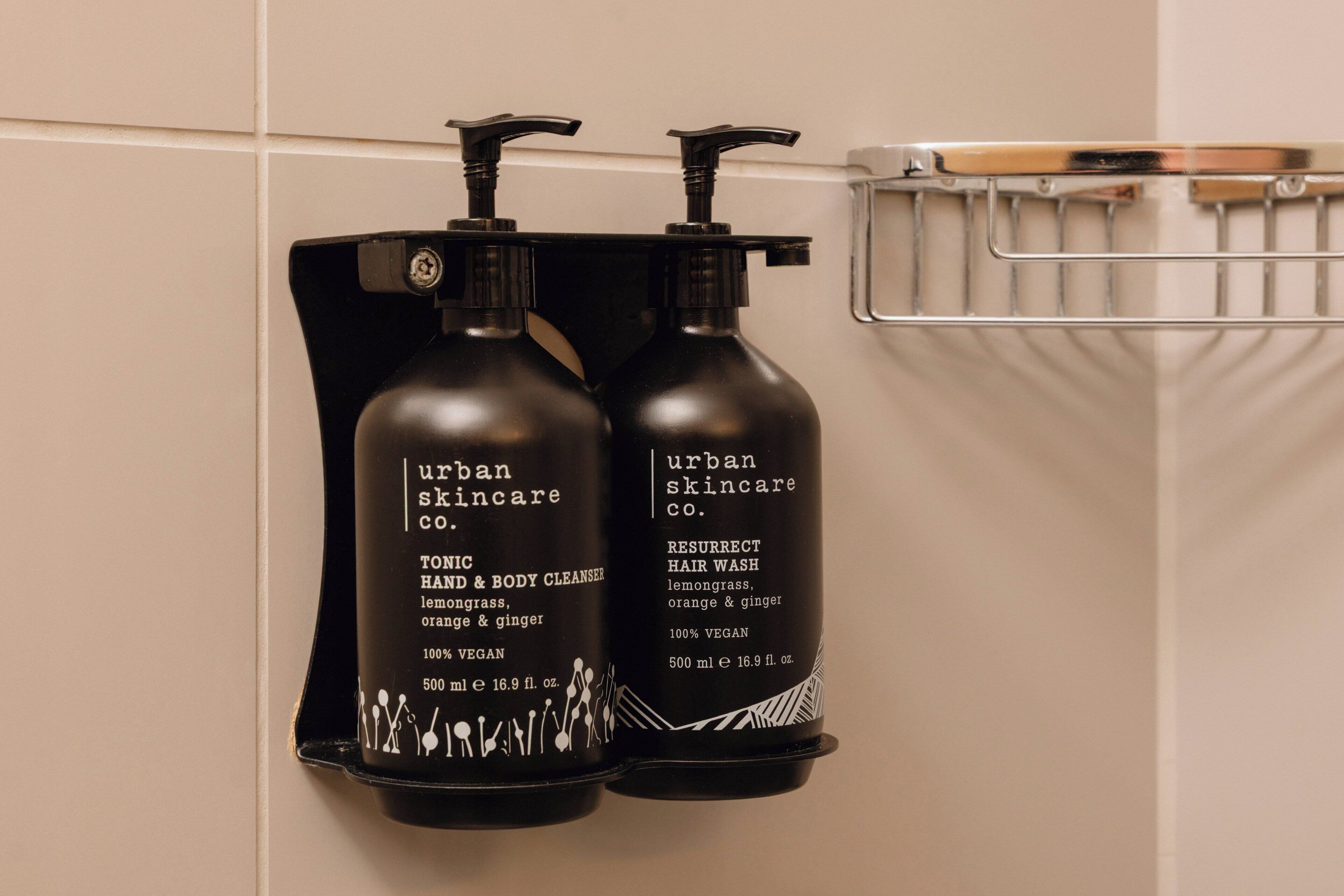 Two bottles of Urban Skincare products on a wall-mounted rack.