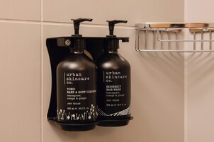 Zwei Flaschen Urban Skincare Produkte auf einem an der Wand befestigten Regal.