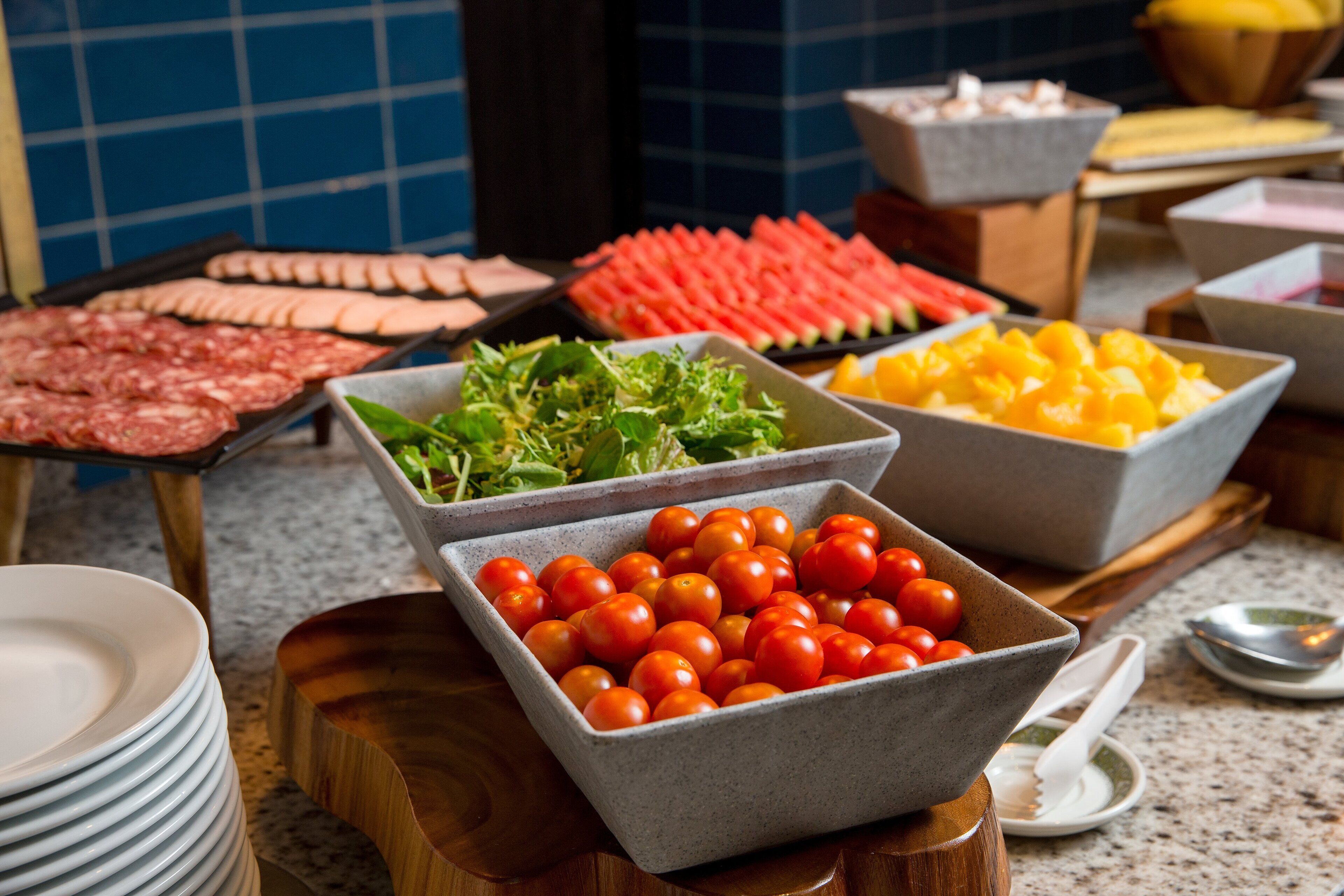 Un bufé con diversos alimentos, incluyendo carnes, verduras y frutas.