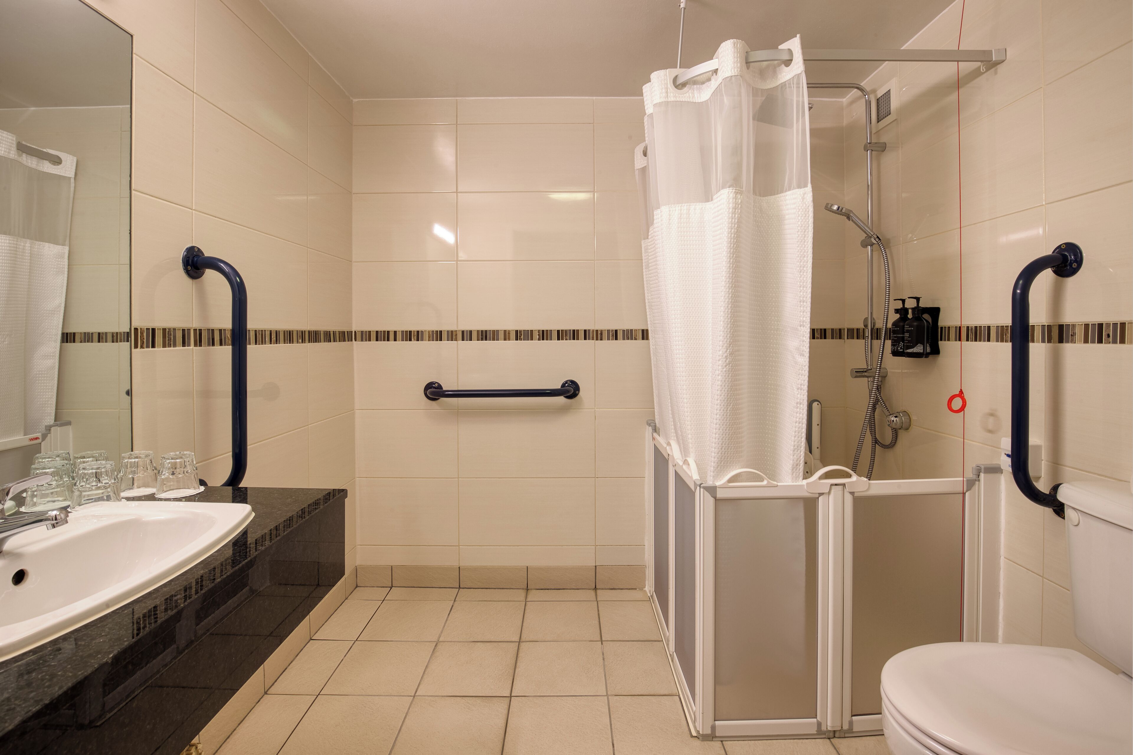 A bathroom with a shower, toilet, and sink.