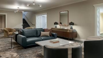 En moderne stue med sofa, sofabord og et stort spejl.