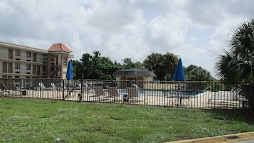 Alberca al aire libre, sombrillas en la alberca y camastros