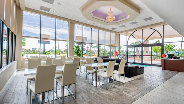 Un amplio espacio interior con ventanas grandes, un mostrador de recepción y zonas de estar.