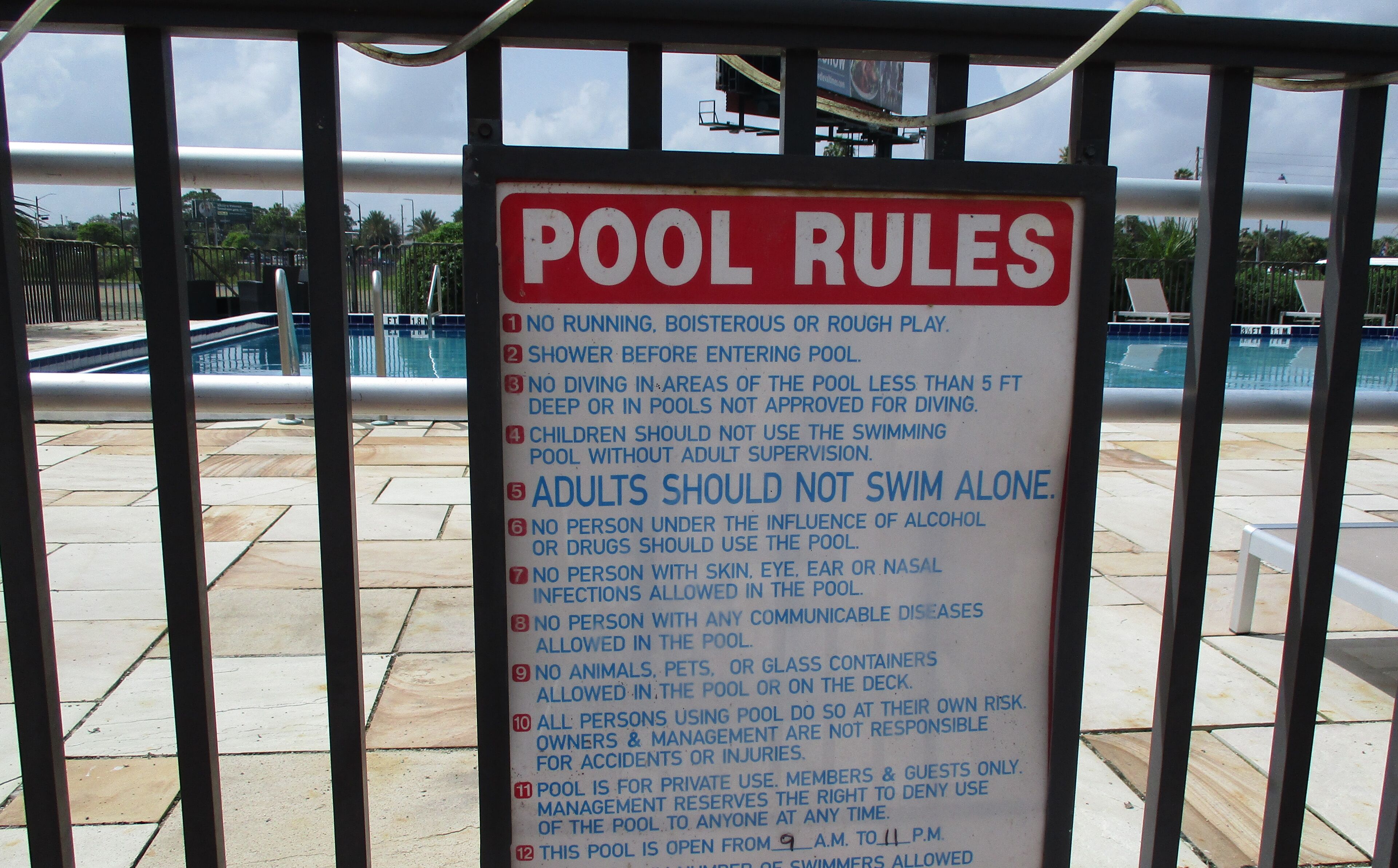 Un cartel de normas de la piscina con una lista de indicaciones para su uso.