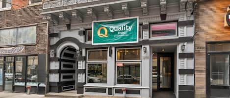 A building with a green sign reading "Quality Inn" by Choice Hotels.