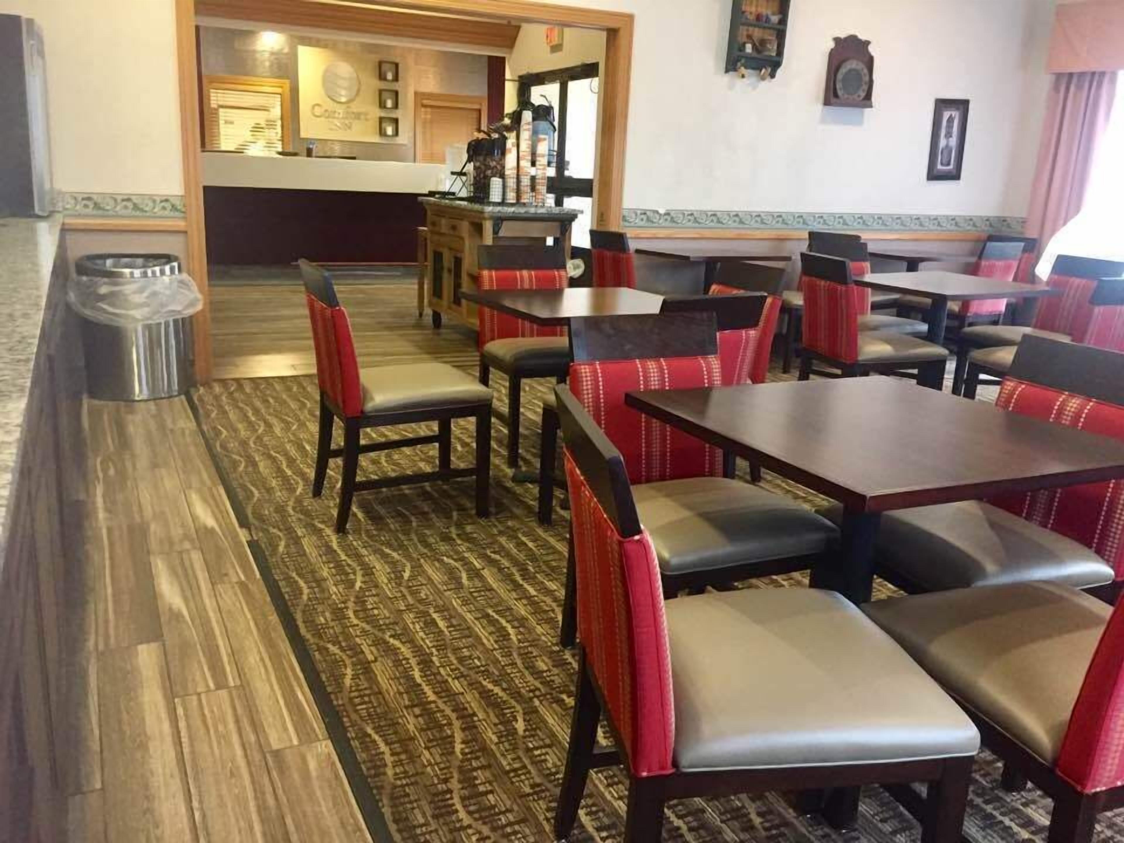 A restaurant with booths and high-top tables, a bar area, and a patterned carpet.