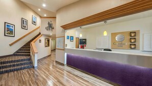 A reception area with a wooden staircase, a reception desk, and a map on the wall. - Comfort Inn Limon (Limon)