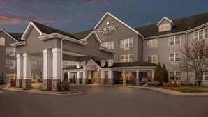 Un hôtel Country Inn & Suites by Radisson doté d’une entrée couverte et de nombreuses fenêtres.