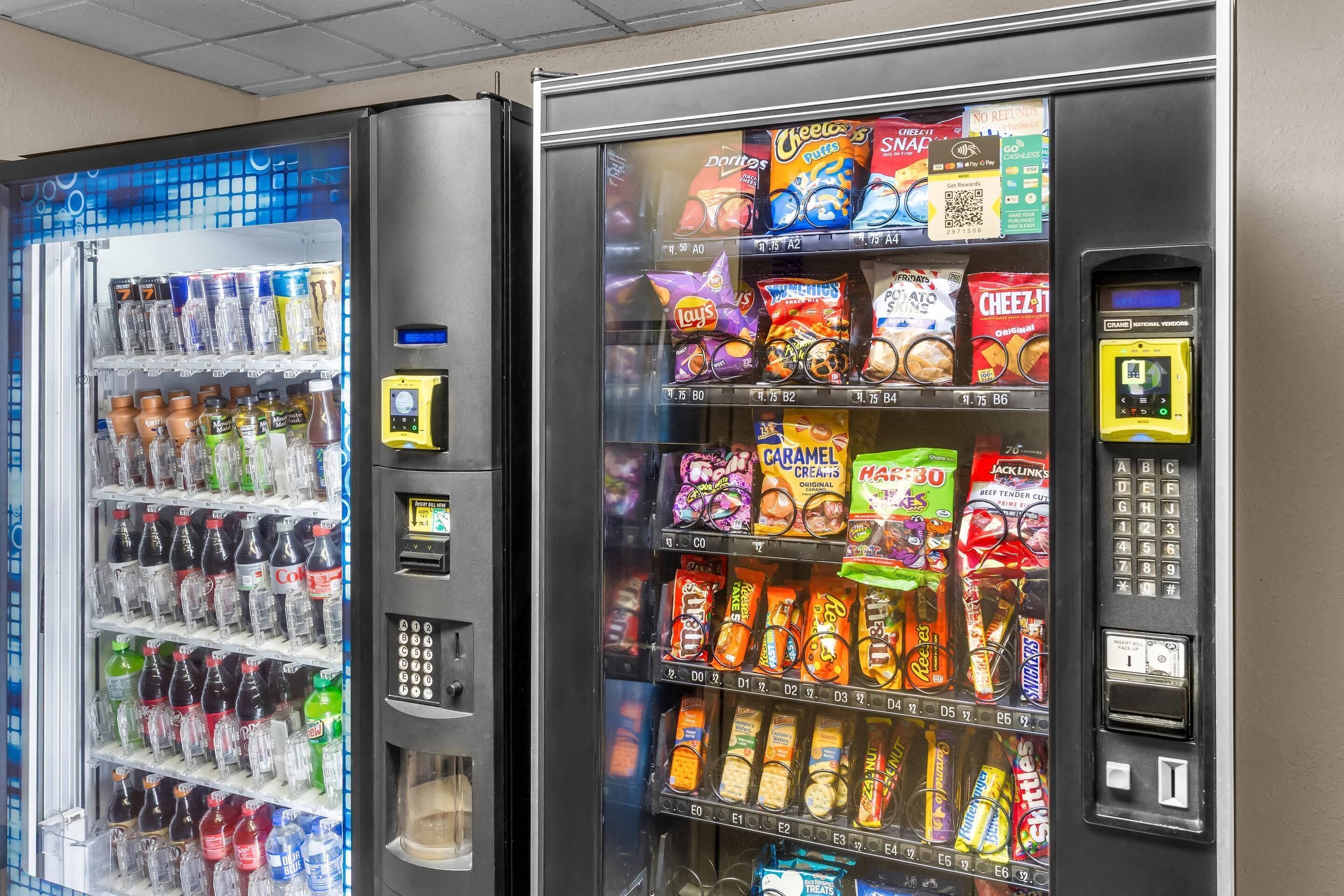 Two vending machines stocked with snacks and beverages.