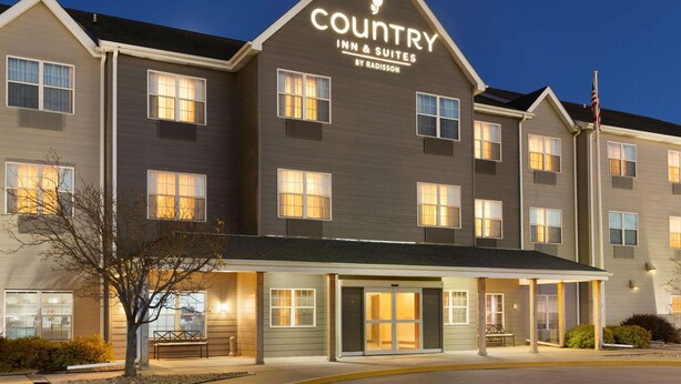 A Country Inn & Suites building with a modern design, featuring a prominent sign at the top and a well-lit entrance. - Country Inn & Suites by Radisson, Kearney, NE (Kearney)