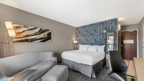 Una habitación de hotel con cama, sofá, escritorio y silla.