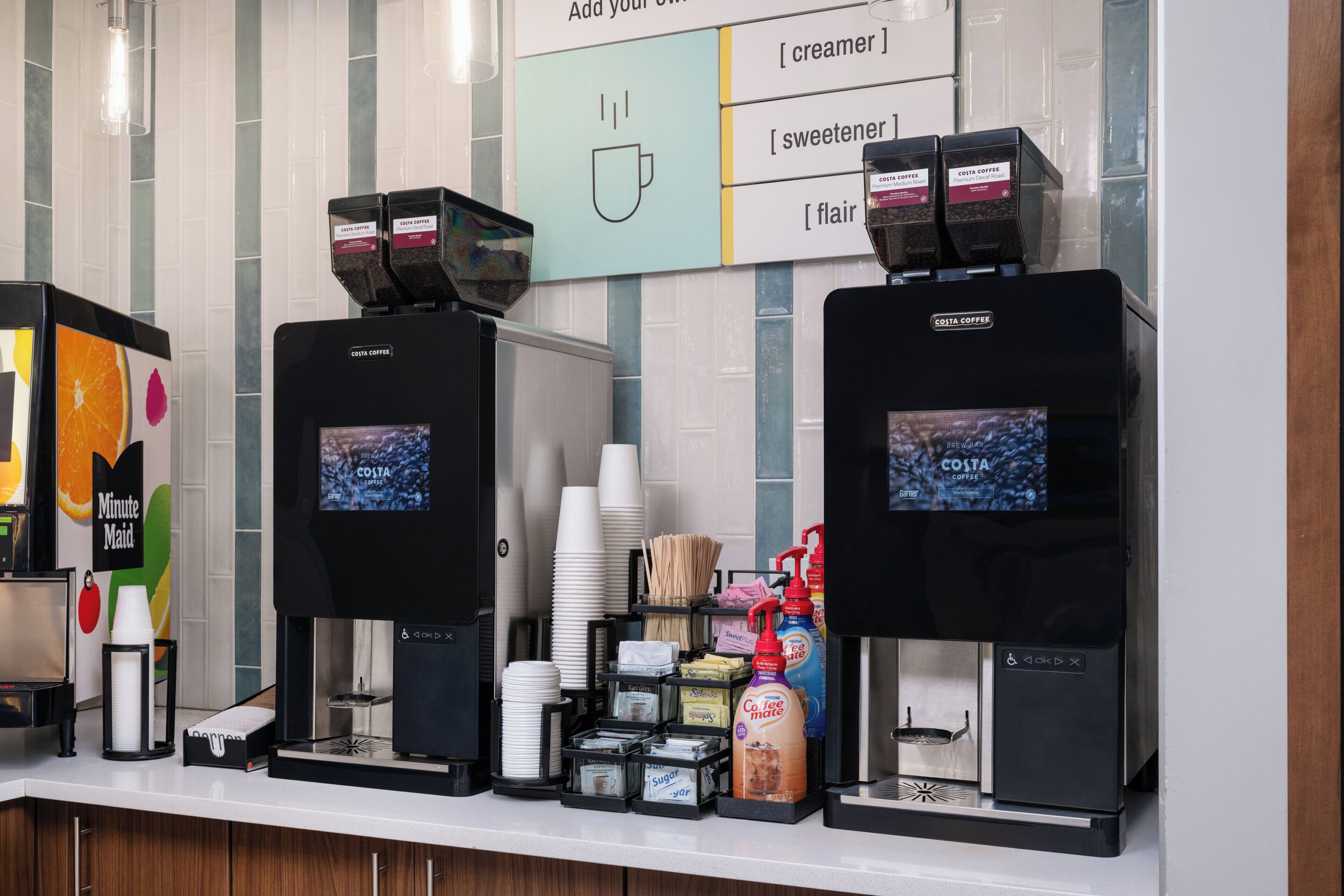 A coffee station with two coffee machines, a menu board, and various coffee-related items.