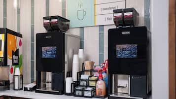 A coffee station with two coffee machines, a menu board, and various coffee-related items.