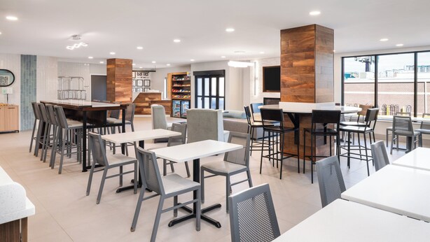 Ein modernes Restaurant mit verschiedenen Sitzbereichen, darunter Tische, Stühle und eine Bar.