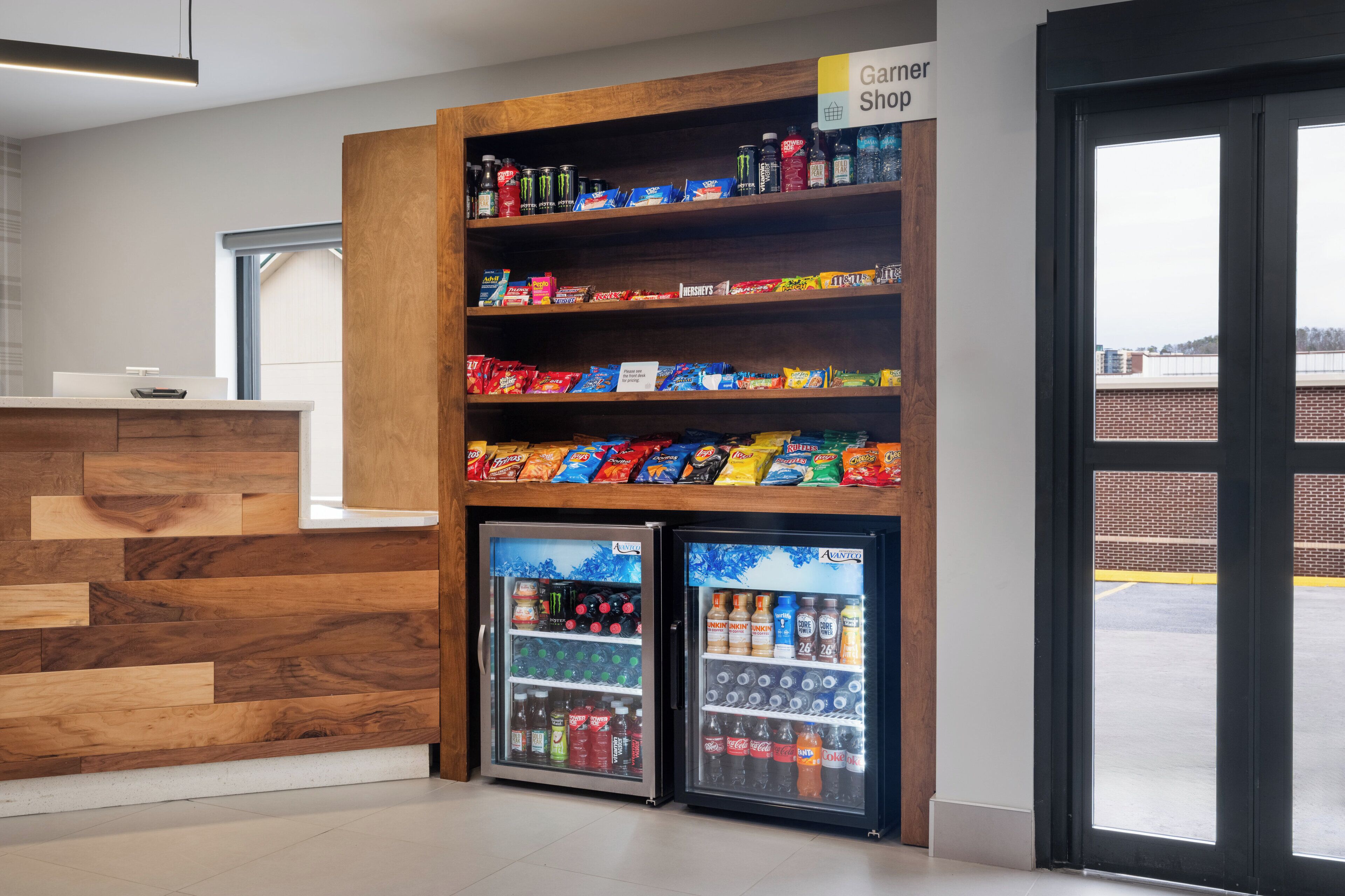 A snack and drink vending area with a wooden counter and two refrigerated display cases.