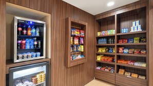 Ein übersichtlich gestalteter Bereich mit Snacks und Getränken, darunter gekühlte Getränke, eine Auswahl an Snacks und verpackte Lebensmittel.