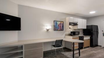 Escritorio, cortinas blackout y tabla de planchar con plancha