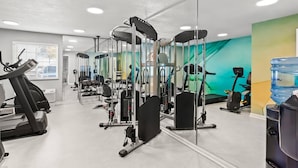 A gym with various exercise machines, a water dispenser, and a large mirror. - MainStay Suites Louisville Jeffersontown (Louisville)