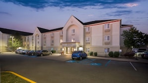 A hotel with a parking lot, marked handicapped spaces, and a sign for MainStay Suites. - MainStay Suites Louisville Jeffersontown (Louisville)