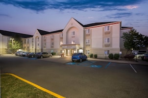 Un hotel con aparcamiento, plazas reservadas para discapacitados y un cartel de MainStay Suites.