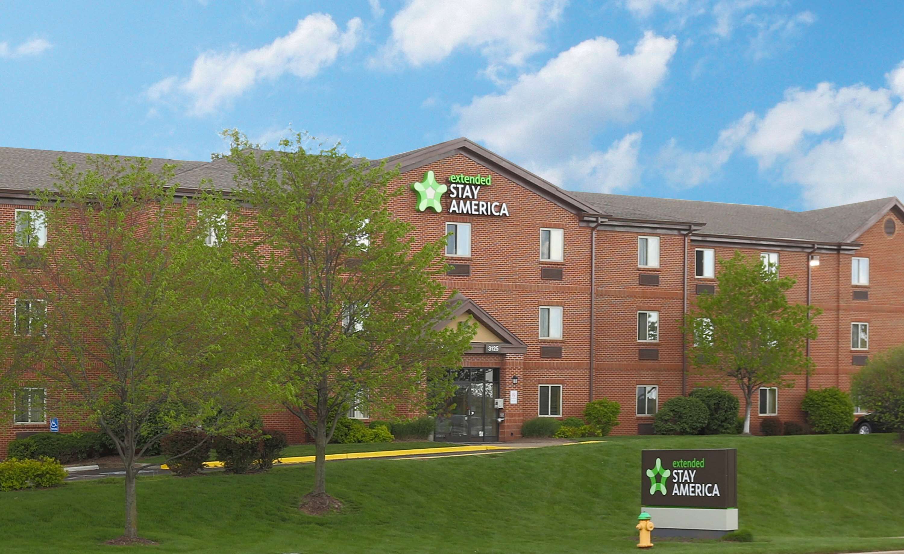 A brick building with multiple windows and a sign reading "extended STAY AMERICA".
