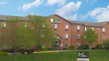 A brick building with multiple windows and a sign reading "extended STAY AMERICA".