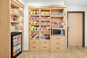 A kitchenette with a microwave, storage cabinets, and a refrigerator. - City Express By Marriott Newport News (Newport News)