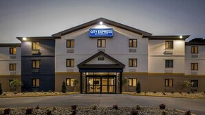 A CITY EXPRESS hotel with a modern design, featuring a prominent entrance and a clear address sign.