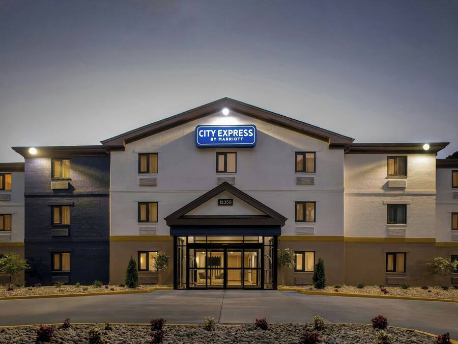 A CITY EXPRESS hotel with a modern design, featuring a prominent entrance and a clear address sign.