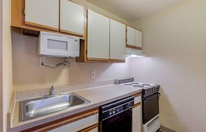 A compact kitchen with a microwave, stove, sink, and dishwasher. - Extended Stay America Select Suites Richmond Innsbrook (Glen Allen)
