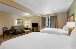 A hotel room with two beds, a sofa, a TV, and a window with curtains. - Extended Stay America Suites Toledo Maumee (Maumee)