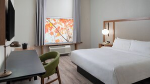 A hotel room with a bed, a desk, a chair, a TV, a window with curtains, and a bedside lamp. - Fairfield Inn & Suites by Marriott Lake Charles Sulphur (Sulphur)