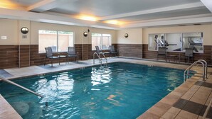 A swimming pool with chairs and tables, a tiled floor, and a wall with a window. - Fairfield Inn & Suites by Marriott Lake Charles Sulphur (Sulphur)
