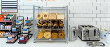 Mostrador de panadería con diversos productos horneados y un letrero que dice 'Baked'.