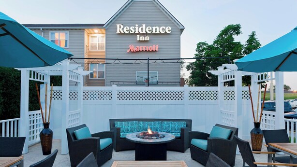 Un'area patio con posti a sedere esterni, un braciere e il cartello di un Marriott Residence Inn.