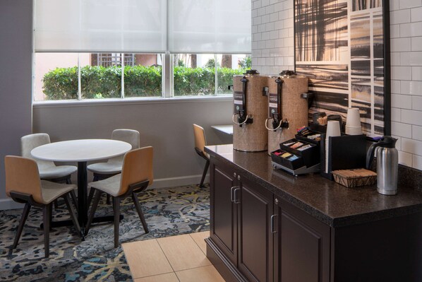 Una cocina moderna con un espacio para café, una mesa redonda con sillas y vistas al exterior.