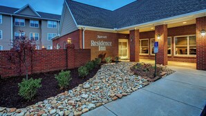 A Marriott Residence Inn with a brick facade, a gravel pathway, and a clear sky.