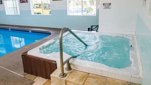Une piscine intérieure avec un jacuzzi et un panneau indiquant qu’il est interdit de manger ou de boire à proximité.