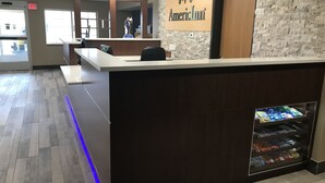 Una recepción con un letrero que dice "American Inn" y una máquina expendedora de aperitivos.