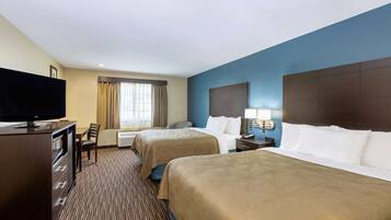 A hotel room with two beds, a TV, a desk, and a chair.