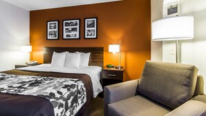 A hotel room with a bed, a chair, a nightstand with a lamp, and framed pictures on the wall. - Sleep Inn Springfield South I60 near Medical District (Springfield)