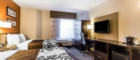 Quarto de hotel com duas camas, uma escrivaninha, televisão e um minibar.
