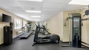 A gym with treadmills, elliptical machines, and a weight machine.