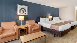 A hotel room with two beds, a sofa, a small table, and a lamp. - Quality Inn & Suites Denver Airport - Gateway Park (Aurora)